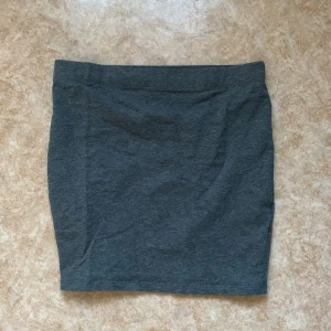 Tajt kjol - Grå tajt kjol i storlek S, går till mitten av låren