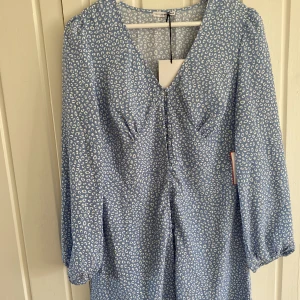 Klänning  - En ljusblå klänning från Nelly i storlek 40. Perfekt sommarklänning som påminner om adoore klänningen. Aldrig använd.