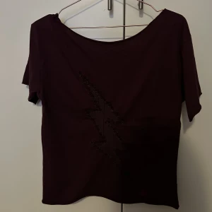 Zadig t-shirt - Snygg t-shirt från Zadig. Vinröd med en blixt på ryggen som har en ”reva”. Zadig logga på ena armen, passar Xs-m.