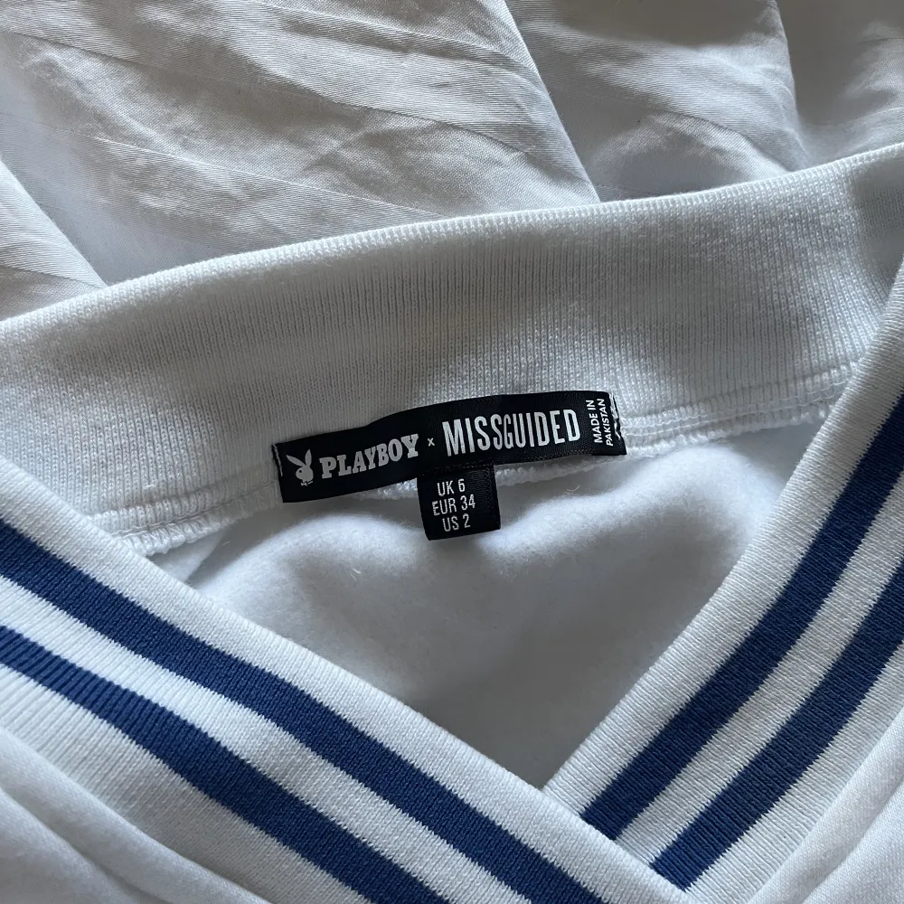 En croppad V ringad tröja från Missguided x Playboy Aldrig använd  Säljes pga kommer ej till användning Nypris 279kr, säljes 200 kr inkl frakt 🩷. Toppar.