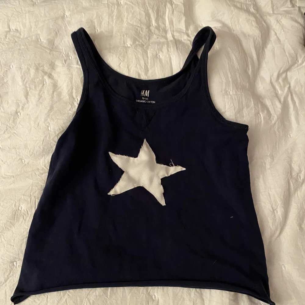 Mörkblått linne med påsydd stjärna. . T-shirts.