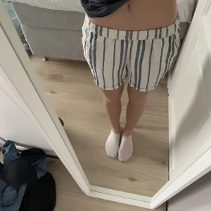 Linne shorts - -Linne shorts. -Storlek 36. -Vit blåa, randiga. -Från Esmara. -Saknar snören. 