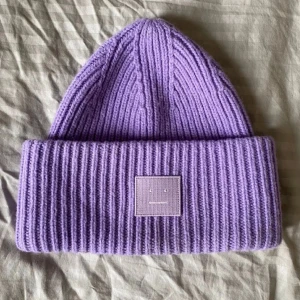Acne mössa - Säljer nu min super söta lila acne mössa med en jätte fin färg. Köpt för 2,5 veckor sedan på johnells för 1265kr och säljer för 550 kr