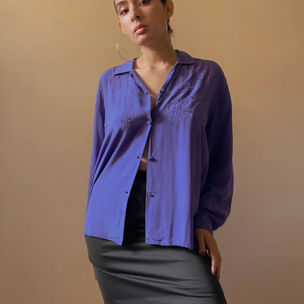 Purple Blouse with Silk Covered Buttons. Soft handfeel. Some light wear and fading of color as it’s a vintage piece.  100% Silk  Flatlay Measurements 63cm Length 55cm Sleeve 46cm Shoulder to Shoulder 110cm Chest 110cm Waist. Toppar.