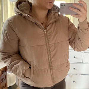 Snygg pufferjacka i beige  - Storlek medium. Använd en säsong. Fräscht skick förutom en skavank som ses på bild 2. Inget men tänker på när man har den på sig. 