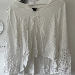 Vit blus - Vit blus med utsvängda armar med mönster.  