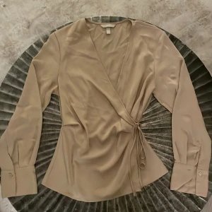 Blus från Gina Tricot - Beige wraparound och uringad blus