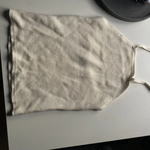 Stickad topp  - ”Stickad” topp från Gina Tricot. Knyter runt halsen, öppen rygg upptill  
