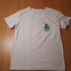 Pickle rick t-shirt - En t-shirt med en mini pickle rick. Den är stor och bekväm. Den har tyvärr en liräten fläck som gör att priset är så lågt.
