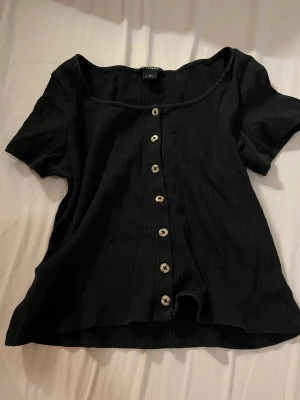 svart topp från monki  - gullig topp med knappar från monki för 20 💕 inga defekter , använd några gånger bara <3  