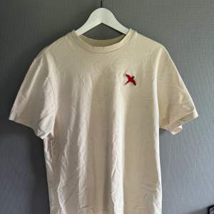 Axel arigato red bird beige t shirt, skick 9/10 den är använd men är som ny, retail: 799-999kr, mitt pris 399kr skriv vid fråga eller funderingar 😊