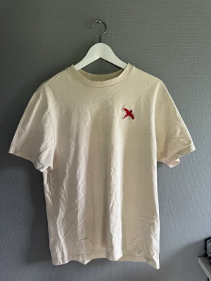 Axel arigato t shirt - Axel arigato red bird beige t shirt, skick 9/10 den är använd men är som ny, retail: 799-999kr, mitt pris 399kr skriv vid fråga eller funderingar 😊