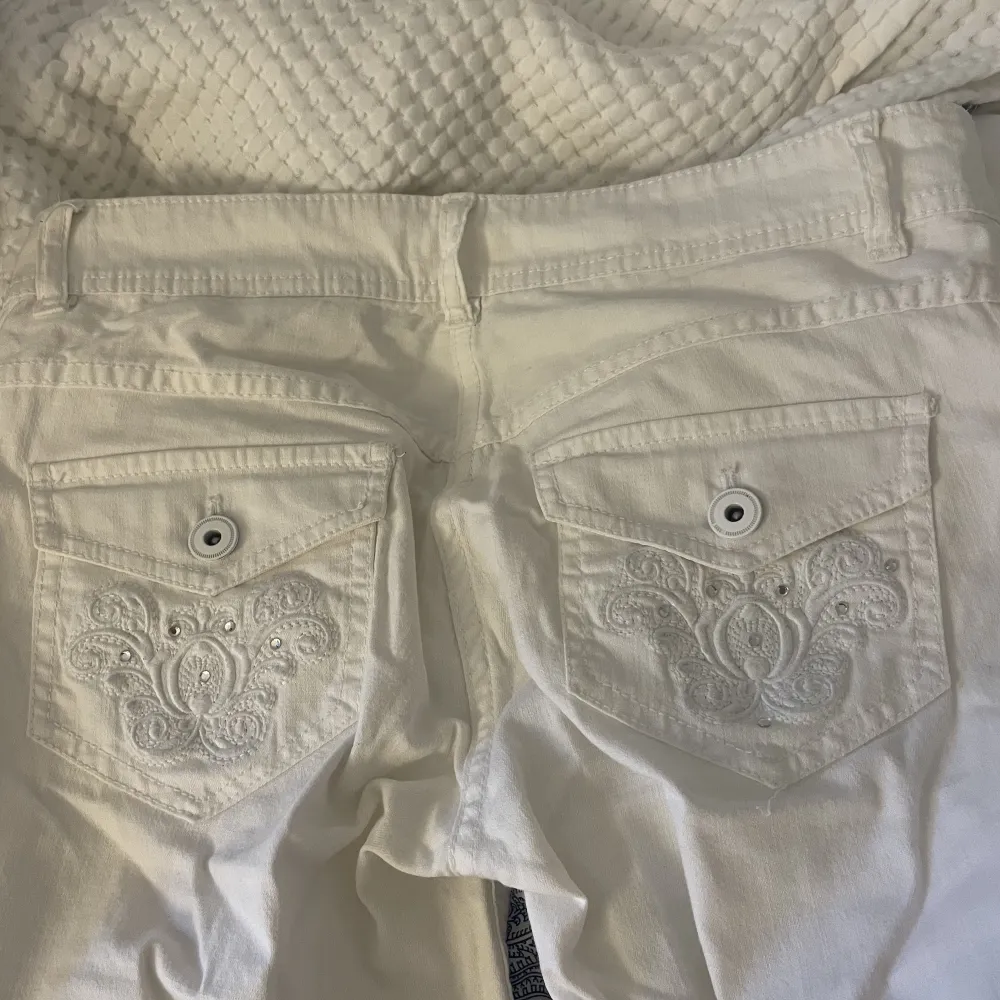 Skitsnygga lågmidjade vita byxor/jeans med riktigt coola fickor från HM. Mer bootcut än vad som framgår på bilderna! Storlek 34 men passar en 32 också, inga defekter och i superbra skick!. Jeans & Byxor.