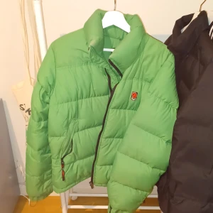 Dunjacka från Fjällräven - Riktigt fin och skön jacka från Fjällräven. Lite sliten här och där (skriv om bilder) men inget seriöst alls. Två olika ɓilde i starten då det var svårt att fånga rätt färg på jackan. Första är med blixt andra inte. Färgen är mittemellan dem två på bilder
