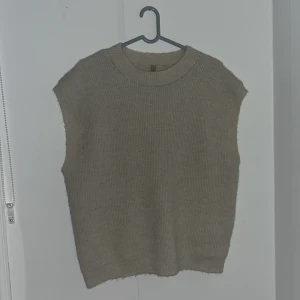 Stickad väst - Jag säljer min tunna stickade väst då den aldrig kommit till användning. Tröjan är i ett skönt material som ej kliar eller sticks.