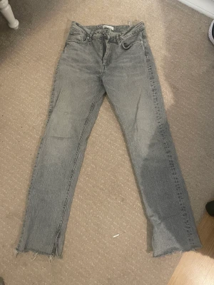 Gråa jeans med slits - Fina ljusgråa jeans från zara. Dom har slits vid benet. Nypris 400kr. 