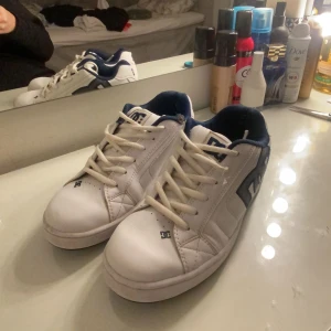 DC skor - Vita DC skor i strl 41. I fint skick förutom ett hål i tyget på högra skon, använda en del och säljer då dem inte kommer till användning längre