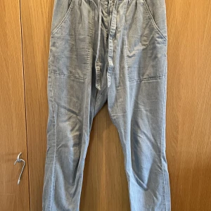 Mys-jeans Marant - Snygga grå jeans med dragsko i midjan. Stora fickor på rumpan. Mått: midja 44 längd 99. Strl 42.