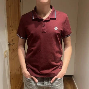 Moncler piké  - Säljer denna Vinröda Moncler Piké eftersom den är lite för liten för mig. Äkthets bevis finns och den är köpte på Sellpy för 1800