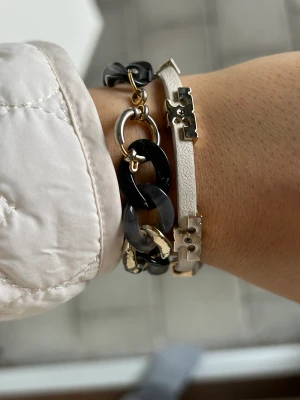 Tory Burcharmband - Vitt och guld i strlk m/l. Använt skick men fortf jätte fint 