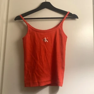 Rött Calvin klein linne - Superfint rött Calvin klein linne med pride-tema! Endast använd en gång. Storlek s. 