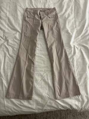Jeans i tunt material, beiga med konstsöm som går över låret och ner till fötterna, fina fake fickor på framsidan. Från H&M storlek 38