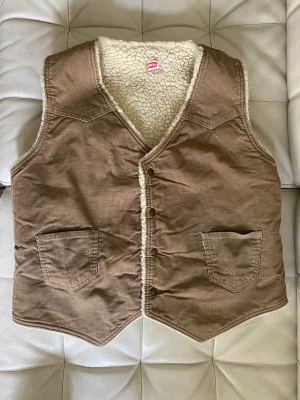 Levi’s väst Manchester  - Fint vintageplagg från Levi’s. Brun Manchester på utsidan och offwhite Teddy inuti. Tryckknappar. Perfekt höstplagg med en varm tröja under. 