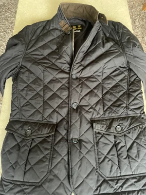 Barbour Quilted Jacket Black - Herrjacka barbour förra årets modell . Knappt använd . Nypris 3000 kr  
