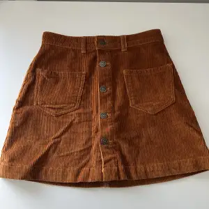Brun kjol med två små fickor i fram