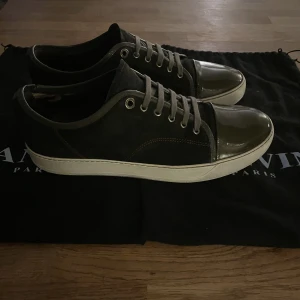 Lanvin skor - Lanvin skor i mörkgrön/brun färg. Skorna är slitna på insidan av skon, (se bild 1) och har använts men fortfarande bra skick. Nypris 4500, mitt pris 2299. Dustbag och box medföljer.