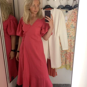 Rosa sommarklänning  - Rosa klänning med omlott-ringning och knyte i sidan. Från Gina Tricots Premium Quality kollektion. I nyskick, endast använd en gång. Materialet är i linneblandning. 