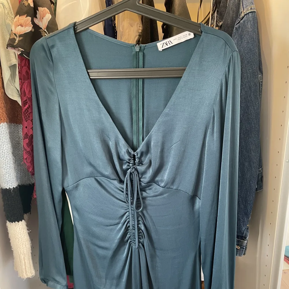 Så fin V-ringad klänning i en mörk och skimrig turkos färg, från Zara. Den knäpps med dragkedja bak. Den kommer sällan till användning, därför säljer jag. Säljer endast till ett bra pris. Använd 1 gång!. Klänningar.