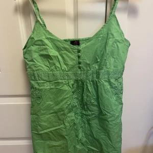 Linne grönt  - super fint linne som passar perfekt till sommaren, jätte fint broderings inspererat mönster på framsidan samt några små knappar!