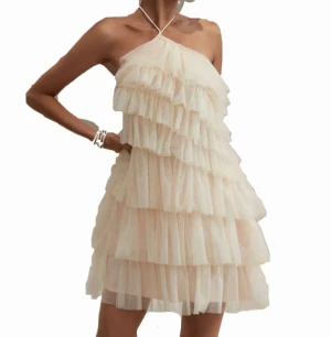 Klänning  - Super fin sommarklänning i ett beig/rosa/glittrigt tyg med massvis av små volanger. 