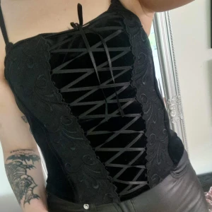 Korsett topp - Köpte på secondhand på flera år sen men tyvärr knappt kommit till användning, har knäppen bak vid ryggen i 2 olika storlekar, inbyggd bh, finns så man kan haka fast axelband, har plastremmar insytt så den blir lite figursydd 