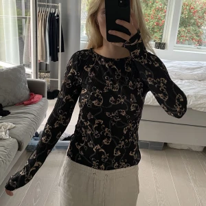 Svart och guld mönstrad långärmad topp från Gina Tricot i storlek XS - Svart och guld mönstrad långärmad topp från Gina Tricot i storlek XS. Tight passform. Supersnygg och lyxig design. Skönt material. Nypris: 300