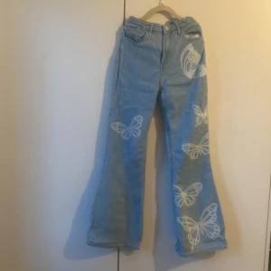  Jeans från H&M  -  Utsvängda  jeans från H&M med nära Vita fjärilar på.