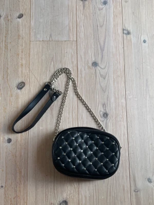 Väska - Svart väska med silver stenar och silver kedja. Två stycken öppningsbara fack🖤knappt använd