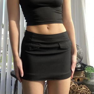 Svart minikjol  - Supersnygg svart minikjol med ”fickor” fram. Uppsydd🥰 Använd en endags gång!