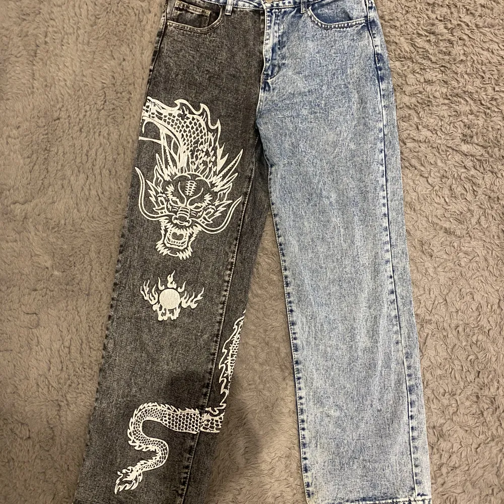 Ett par skit snygga jeans, ena benet är blått och det andra mörk grått med en kinesisk drake på🩵🩶🐉 Har bara haft på mig de typ en gång, så de är i princip typ oanvända, skriv om du vill ha mer specifika mått på byxorna🌸Prisändring kan ske vid snabbt köp. Jeans & Byxor.