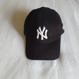 NY keps  - Har en liten solblekt fläck som inte är markant synlig.