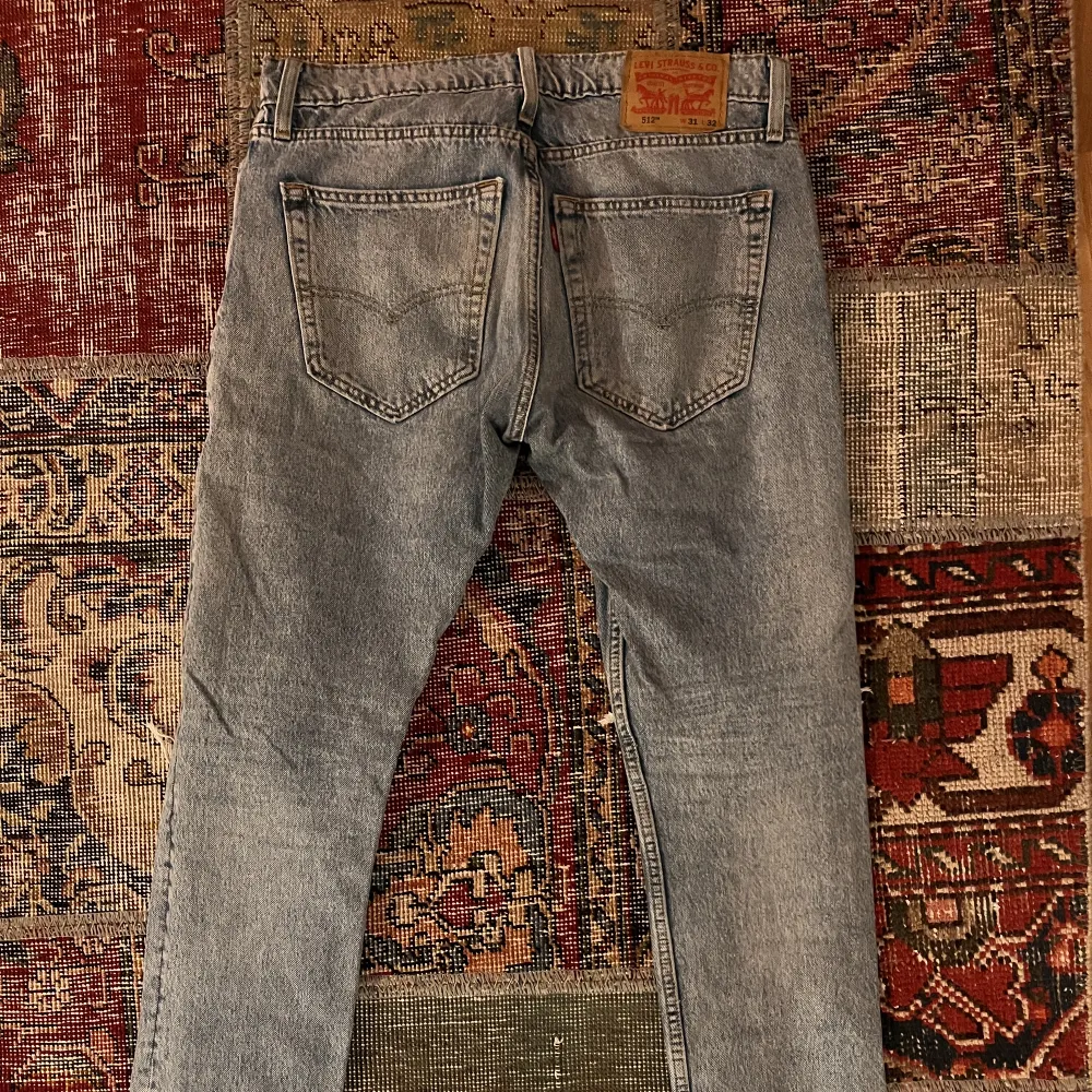 Ljusa Levi's 512 jeans med en karaktäristisk patina av slitage. Trots detta är de i mycket bra skick. Storlek 31/32. Perfekt för den som uppskattar vintagekänslan med Levi's kvalitet.. Jeans & Byxor.