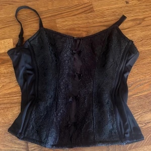 Svart korsett - Svart korsett perfekt till fester eller middagar, säljer då den är för liten på mig, man kan justera axelbanden