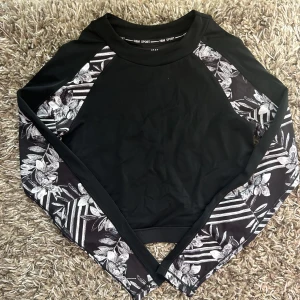 Långärmad träningströja  - Svart långärmad träningströja med mönstrade ärmar. Aldrig använd. Storlek M men skulle säg att den även passar mindre. 