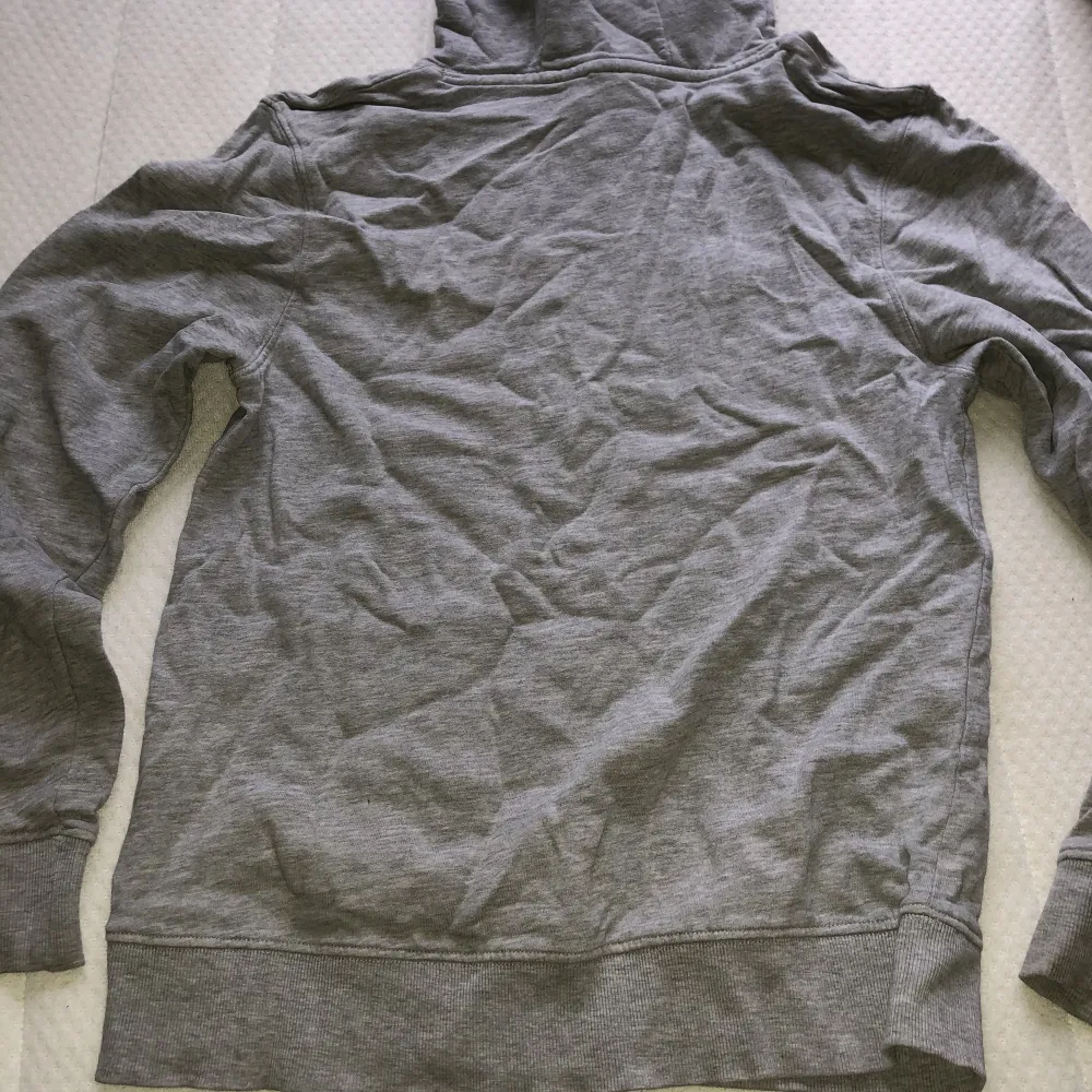 Finns två små hål vid fickan på båda sidorna men är knappt märkbara. Längd ca 60cm. Ärmlängd ca 62cm. Vikt ca 430g. . Hupparit & Collegepaidat.