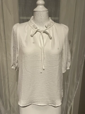 Söt vit topp  - Aldrig använd. Knyt där fram och gummiband i slutet på armarna. 