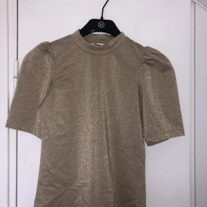 Guld glitter t-shirt - Säljer denna sjukt fina guldiga topp från Kappahl då den inte kommer till användning 