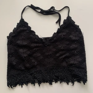 Croptop - Svart croptop med halterneck från bikbok med spetsdetaljer och dragkedja i ryggen. 