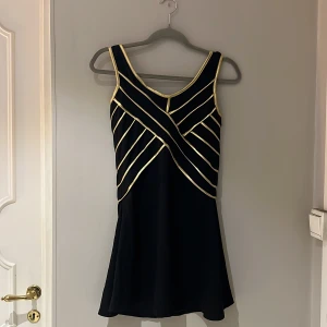 Klänning i svart och guld - Söt klänning i svart och guld från Stylebystars. Strl S