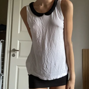 Blus - Gullig vit blus med svarta vikta kanter runt nacken🤍 Köpt på Lindex. Jättefint skick!